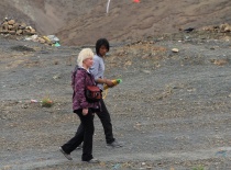 На фотографии изображены два человека, гуляющих по горному ландшафту. Вокруг них видны камни и флаги