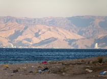 На фотографии вид на море с пляжем и гористой местностью на заднем плане. Вероятно, это побережье Эй