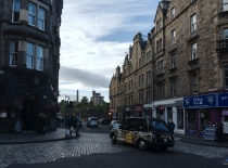 На фотографии изображена улица в старинном районе города, вероятно, это Эдинбург. Видны исторические