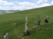 На фотографии изображены древние каменные изваяния, расположенные на зелёном холме. Это место, вероя