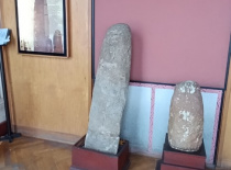 Два каменных артефакта, выставленных в помещении музея. Они находятся на по