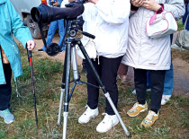 На фотографии группа людей, занимающихся наблюдением за природой с помощью телескопа. Скорее всего,
